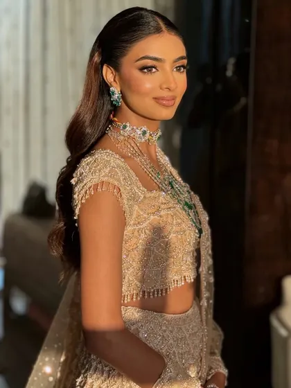 A side profile showing the beautiful waves in her hair and the stunning details of her jewelry.