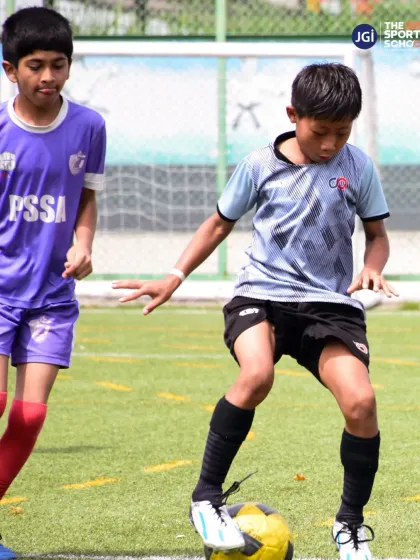 A young U13 player skillfully maneuvers the ball, demonstrating the close control and footwork we teach at the grassroots level.