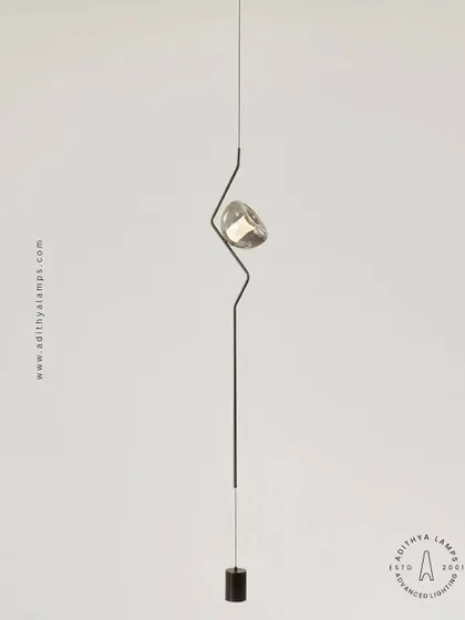 An innovative ceiling-to-floor light installation. This fixture uses tension wires to create a slender, minimalist line of light with a single adjustable spotlight, adding a dramatic and futuristic element to any modern space.