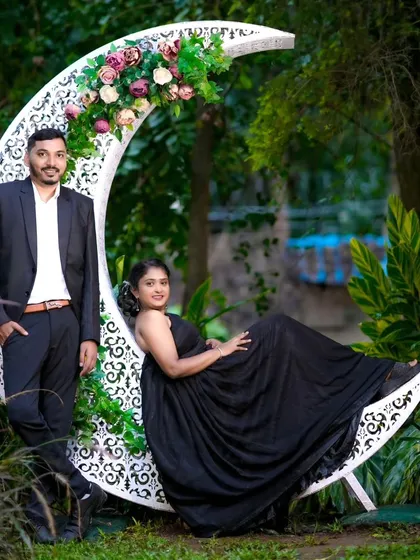 A beautiful maternity moment captured during a couple's photoshoot. The crescent moon prop decorated with flowers adds a touch of magic to this special memory.