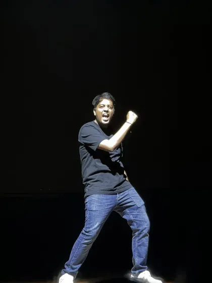 Another dynamic action shot of Aakash Gupta, known for his 'Excuse Me Brother' catchphrase, on stage.