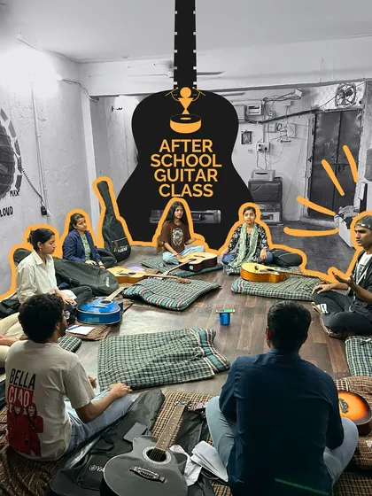 An after-school guitar class in session. Students learn in a relaxed, peer-supported environment, where they can practice chords and rhythms together, building both skills and friendships.