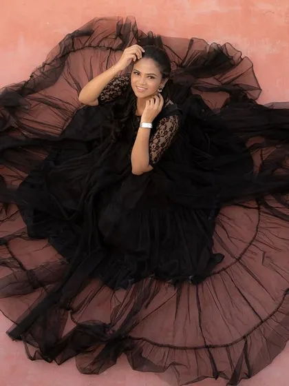 For a truly glamorous and artistic maternity shoot, this black net gown is a showstopper. The voluminous ruffled skirt creates a stunning silhouette from every angle.