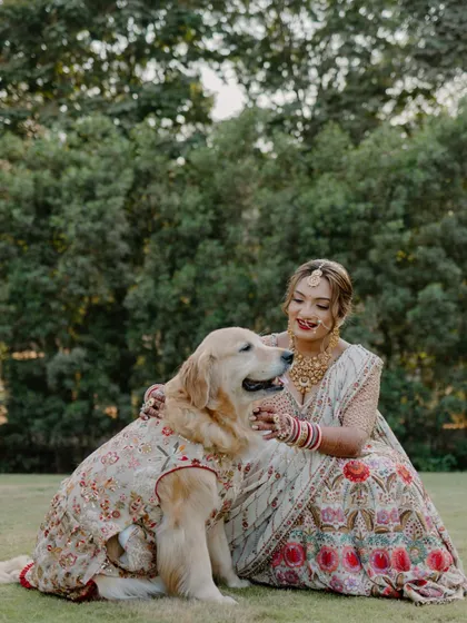 A heartwarming moment between the bride and her furry best friend, who is also dressed for the occasion. This shows that family comes in all forms.