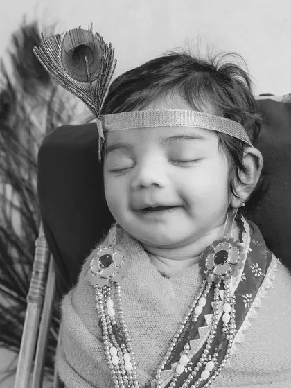 The same divine newborn portrait, presented in timeless black and white. This version emphasizes the beautiful textures and the baby's peaceful expression.