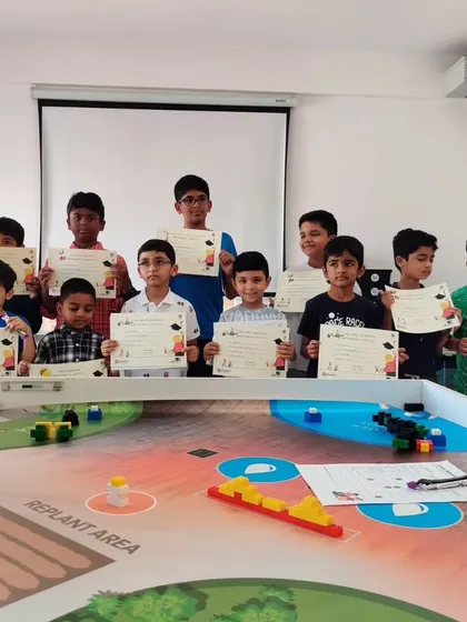 A proud group of students holds up their completion certificates after a successful term. These documents represent a significant step in their journey of learning robotics and STEM.