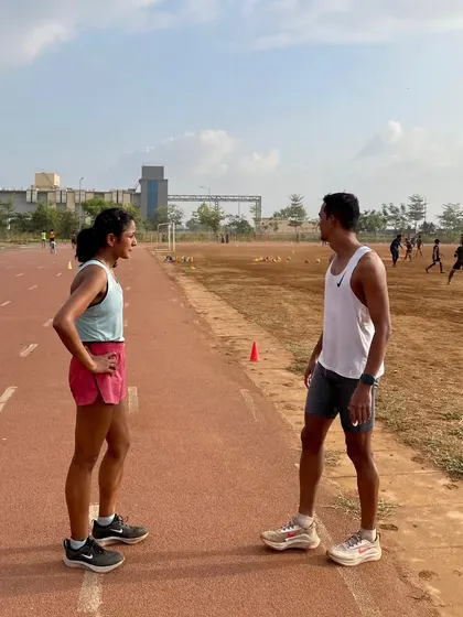 Competition happens at the bottom, people at the top collaborate. A coaching moment on the track, discussing strategy and form.