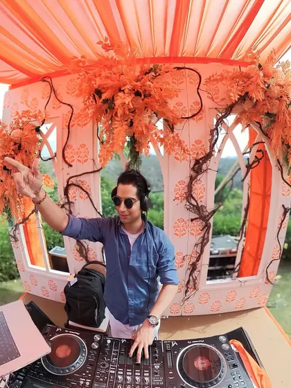 A sundowner party is all about the right vibe. Here I am, set against a stunning orange-themed decor, curating a mix of chill and upbeat tracks as the sun sets. It's the perfect soundtrack for a beautiful daytime celebration.