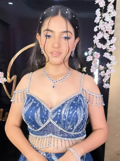 A trendy hairstyle for a younger client, featuring open waves and face-framing tendrils with pearl accents. This is a fresh and modern look for a pre-wedding party.