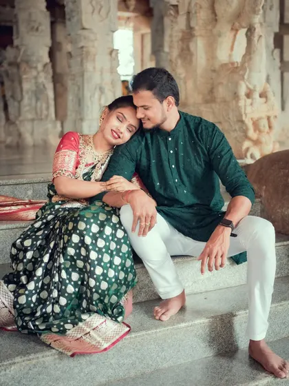 A quiet, intimate moment between a newly married couple on the steps of a temple, away from the crowds.