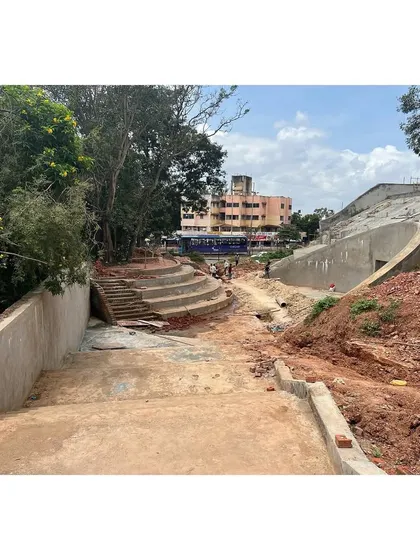 A construction view of the University Sports Center, showing how the structure is nestled into the ground. The design connects to the campus through a series of terraced plazas and steps.