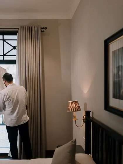 A quiet, documentary-style shot of the groom inspecting his wedding attire. These behind-the-scenes moments build the narrative of the day.
