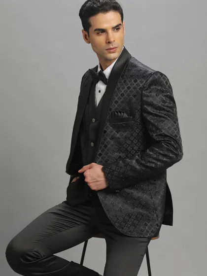 A closer look at the black embroidered tuxedo. Notice the subtle pattern and the classic shawl lapel, details that make this pre-loved piece a timeless addition to your collection.
