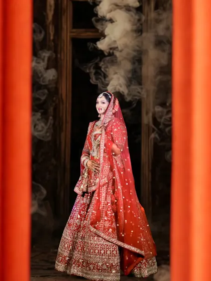 A stunning bridal portrait with a cinematic feel. The bride is framed by orange pillars, with smoke creating a dreamy, ethereal atmosphere around her.