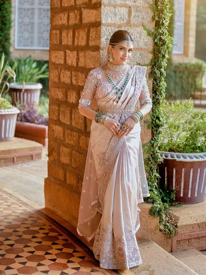 The bride stands tall and confident in her custom-designed saree and blouse. The entire look is a celebration of her unique style and personality.