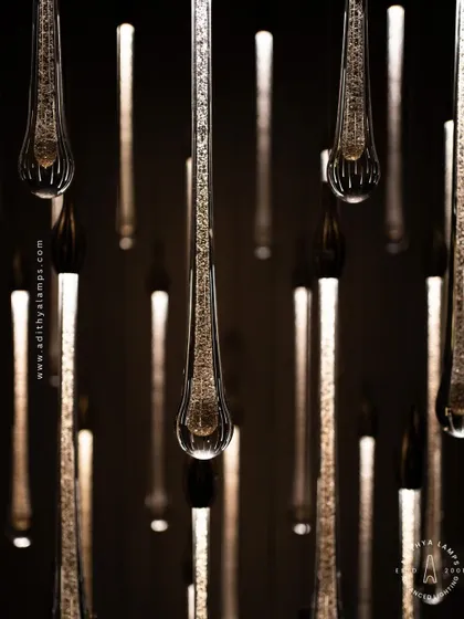 A stunning cluster of crystal teardrop pendants. Each pendant contains bubble-like inclusions that catch the light, creating a sparkling, rain-like effect. This is an elegant choice for double-height foyers or modern staircases.