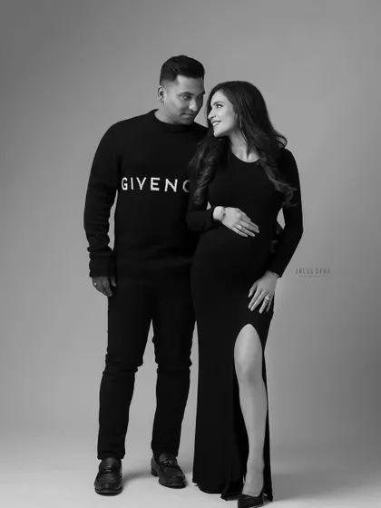 A chic and modern maternity portrait in black and white. The couple's stylish all-black outfits create a timeless and sophisticated look.