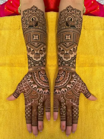 A personalized bridal design with the couple's names, surrounded by peacocks and other traditional motifs.