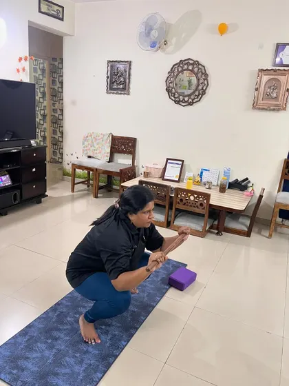 A client holds Malasana (Garland Pose), a deep squat that is excellent for hip mobility and digestive health.