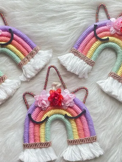 A trio of magical unicorn wall hangings. Each features a pastel rainbow with delicate flower embellishments, perfect for adding a touch of fantasy to a child's room.
