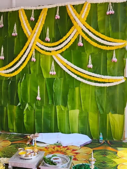 A simple and natural backdrop made entirely of fresh banana leaves, decorated with jasmine flower garlands. This is perfect for eco-friendly and traditional ceremonies.