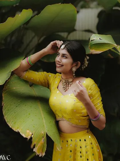 A beautiful portrait of the bride during her Haldi photoshoot, her smile radiant against the natural backdrop.