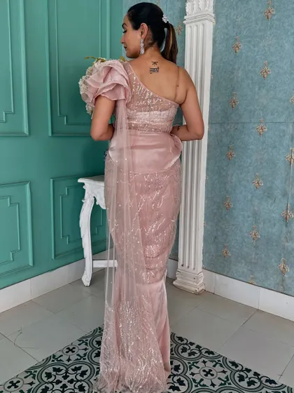 The back view of this elegant pink draped saree, showing the one-shoulder design and sparkling fabric.