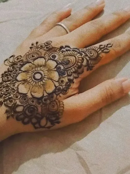A delicate and pretty floral design on the back of the thumb and index finger. This is a great example of a small, minimalist design that still makes a beautiful statement.
