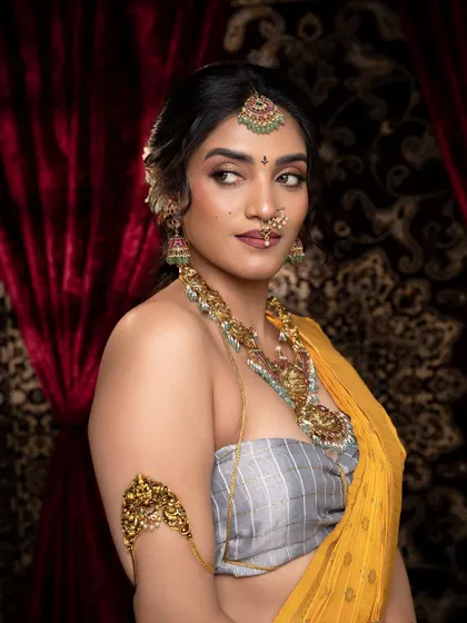 This side profile highlights the intricate vanki (armlet) and the detailed work on the necklace. The antique finish gives it a beautiful, timeless quality.