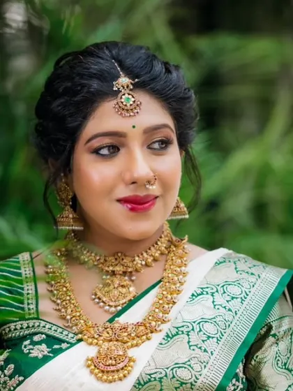 A close-up of the beautiful mom-to-be. The saree drape perfectly frames her face and jewelry, highlighting her pregnancy glow.