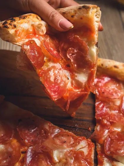The first slice of a classic pepperoni pizza. It's a moment of pure joy.