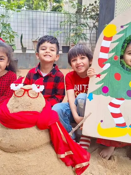 A creative Christmas scene made with sand! The children built a sand-snowman and posed with a festive photo board, showing their imaginative spirit.