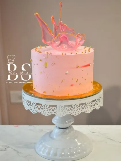 A finished pink whipped cream cake with an elegant isomalt sculpture, demonstrating the beautiful and modern techniques taught in my class.