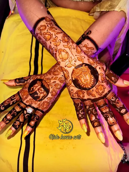 A beautiful back hand design for a client, featuring traditional figures of a goddess and an elephant inside circular frames. The floral patterns around it complete the look.
