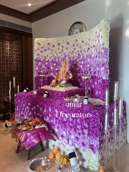 My ombré floral walls are a huge hit for Ganesh Chaturthi. This mandap showcases a beautiful gradient of purple and white flowers, creating a dense, luxurious backdrop for Bappa. The design is complemented by modern candle stands for a soft glow.