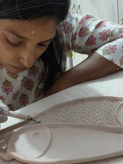 My student Sukanya, a journalist by profession, is seen here carefully carving a fish platter. Our sessions are filled with interesting conversations about everything from music and pets to politics, all while creating with clay.