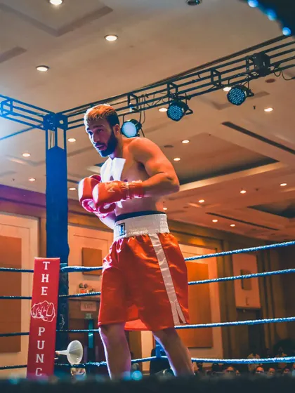 A fighter standing ready in the ring, a picture of focus and preparation.