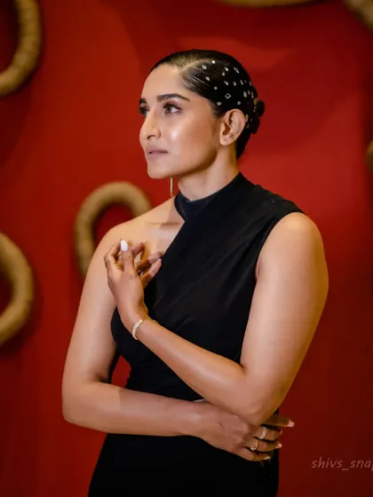 A close-up portrait showcasing the clean lines of the black mermaid gown's one-shoulder neckline. It's a minimalist yet powerful design detail.