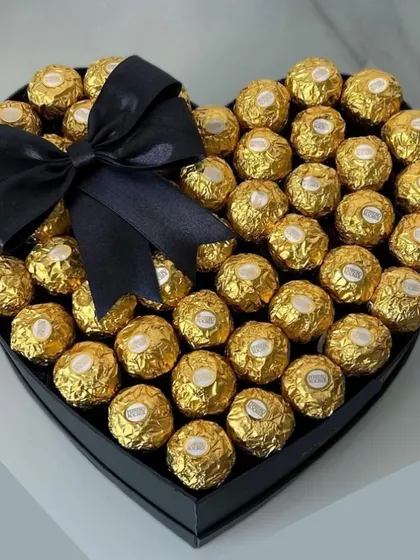 A sleek and modern take on a romantic classic. This black heart-shaped box is filled to the brim with Ferrero Rocher chocolates and tied with a simple black bow.