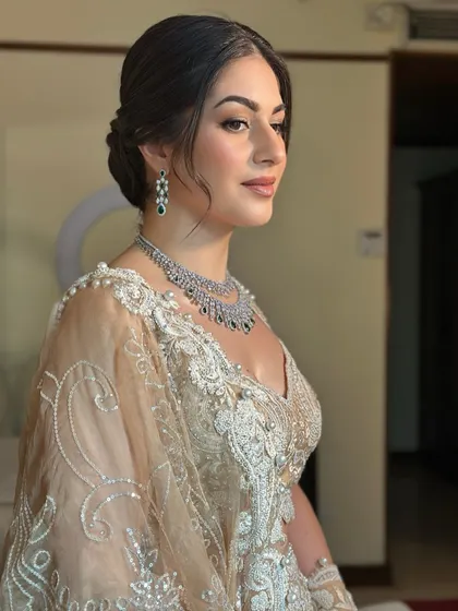 A side profile showing the intricate details of her hair and the soft glow on her skin. It's a look of pure, understated elegance.