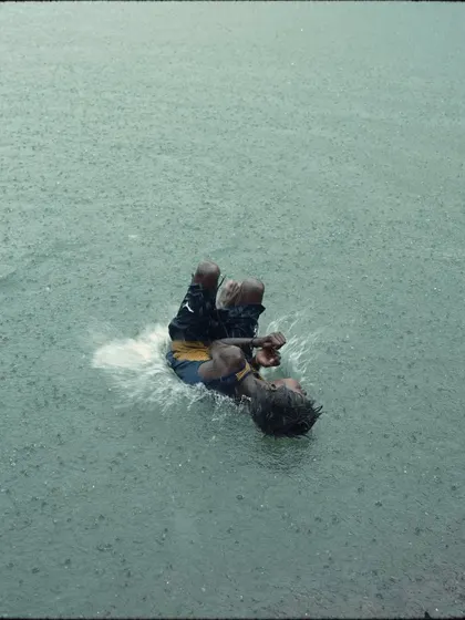 A boy emerges from the water, caught in the middle of the downpour. This image captures the feeling of being completely immersed in the monsoon rain.