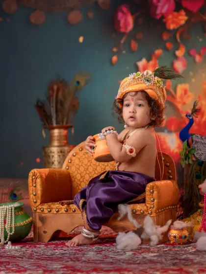 A candid moment of your little Krishna, looking curious while seated on his small throne. I focus on capturing these natural expressions that make each photo special.