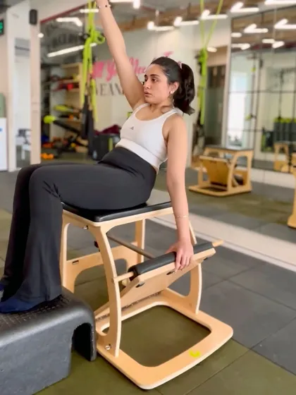 It's not just about the reformer. We use a variety of equipment like the Pilates Chair to challenge your balance, stability, and strength. This exercise targets the obliques and improves spinal mobility, all with precise control.