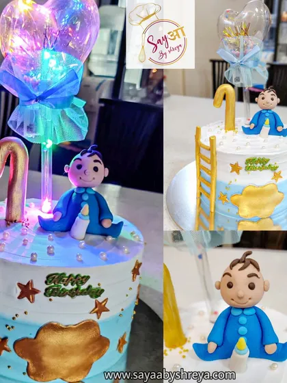 A magical cake for a baby boy's first birthday. This design includes a cute fondant baby, a ladder to the stars, and a light-up balloon topper that adds a special glow to the celebration.