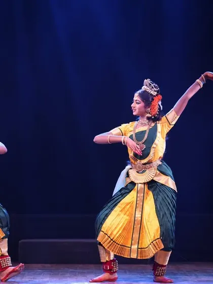 Two dancers in a graceful, flowing pose, their movements complementing each other beautifully on the Sadhana festival stage.