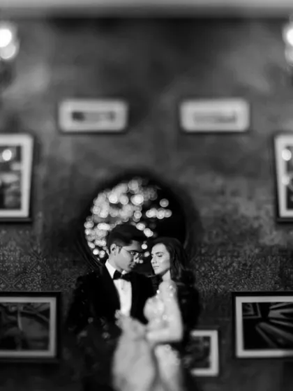 An artistic black and white portrait of the couple, with beautiful bokeh lights in the background creating a dreamy effect.