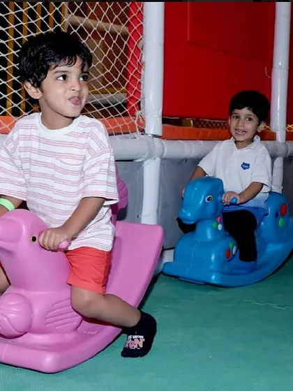 Two boys enjoy a race on the rocking horses in our dedicated toddler play area.