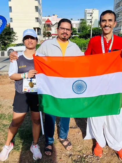 Three participants celebrate with the Indian flag after the run, showcasing the diverse community that joins our events.