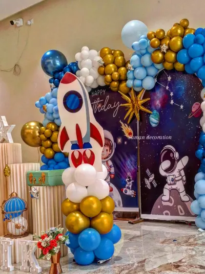 A side view of the astronaut-themed birthday party, highlighting the rocket ship cutout and balloon arrangement.