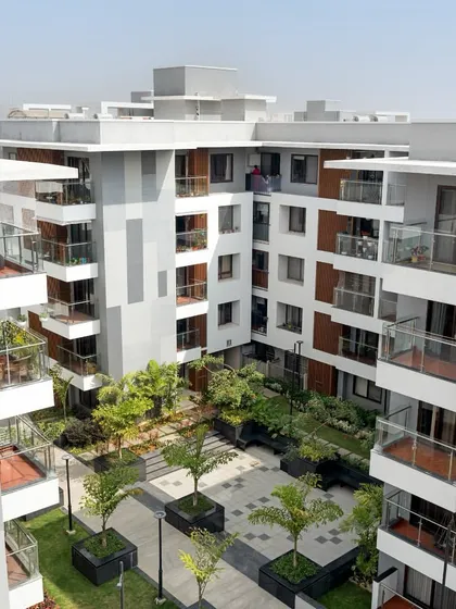 An aerial perspective of the Sona Vistaas residential cluster in Bengaluru, where buildings are organized around a central, verdant courtyard. This layout is a core principle of my township planning, designed to enhance microclimates and create a shared sense of place.
